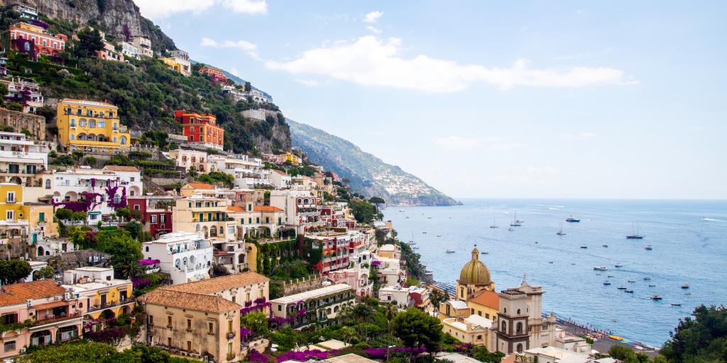 Colourful houses cling to a cliffside on the coast in Positano, Italy