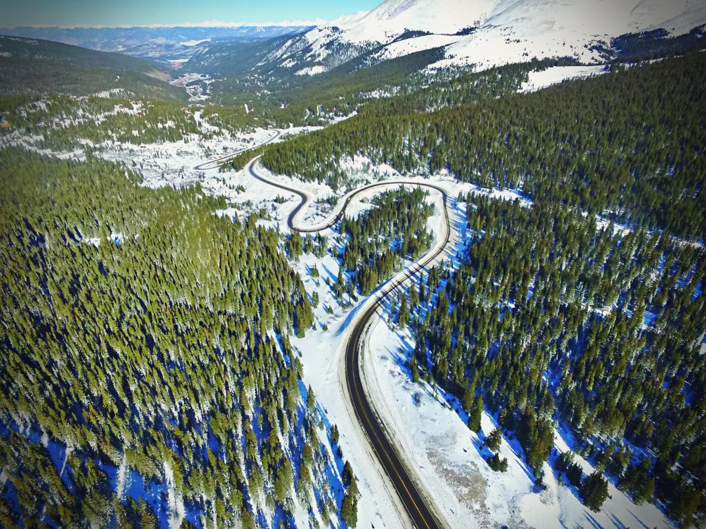 Aerial view of the Hoosier Pass windy road through the Rockies near Breckenridge, Colorado, with the road cutting through snowy forest