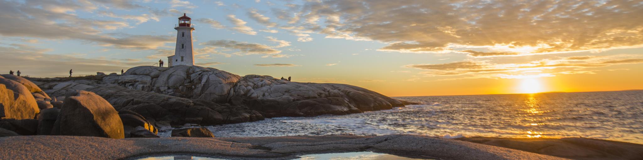 Peggy's cove lighthouse, Halifax, Nova Scotia with huge rock sunset ocean view landscape.