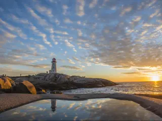 Peggy's cove lighthouse, Halifax, Nova Scotia with huge rock sunset ocean view landscape.