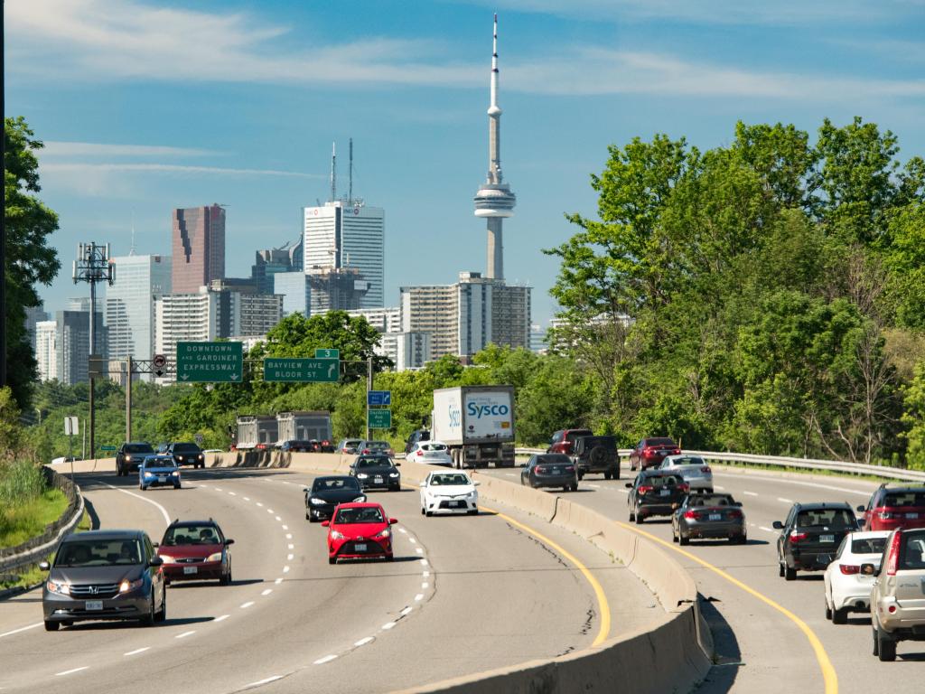 Cars on a highway with the CN Tower in the background on a sunny day