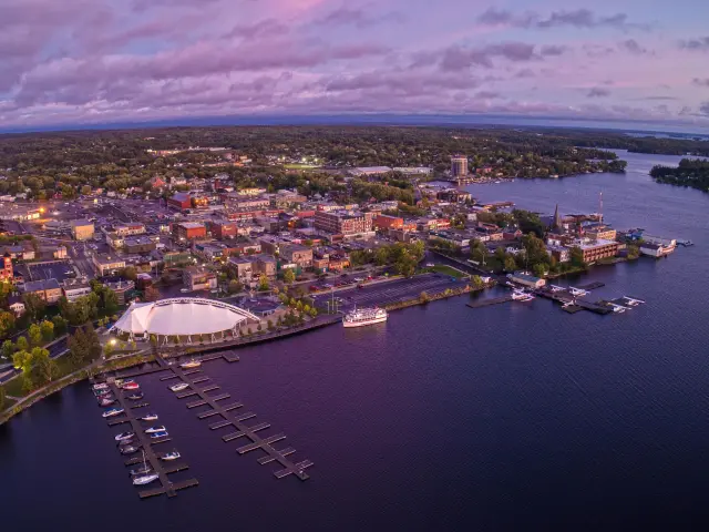 Aeriel view of the lakeside city during a purple sunset, with boats docked at the harbor