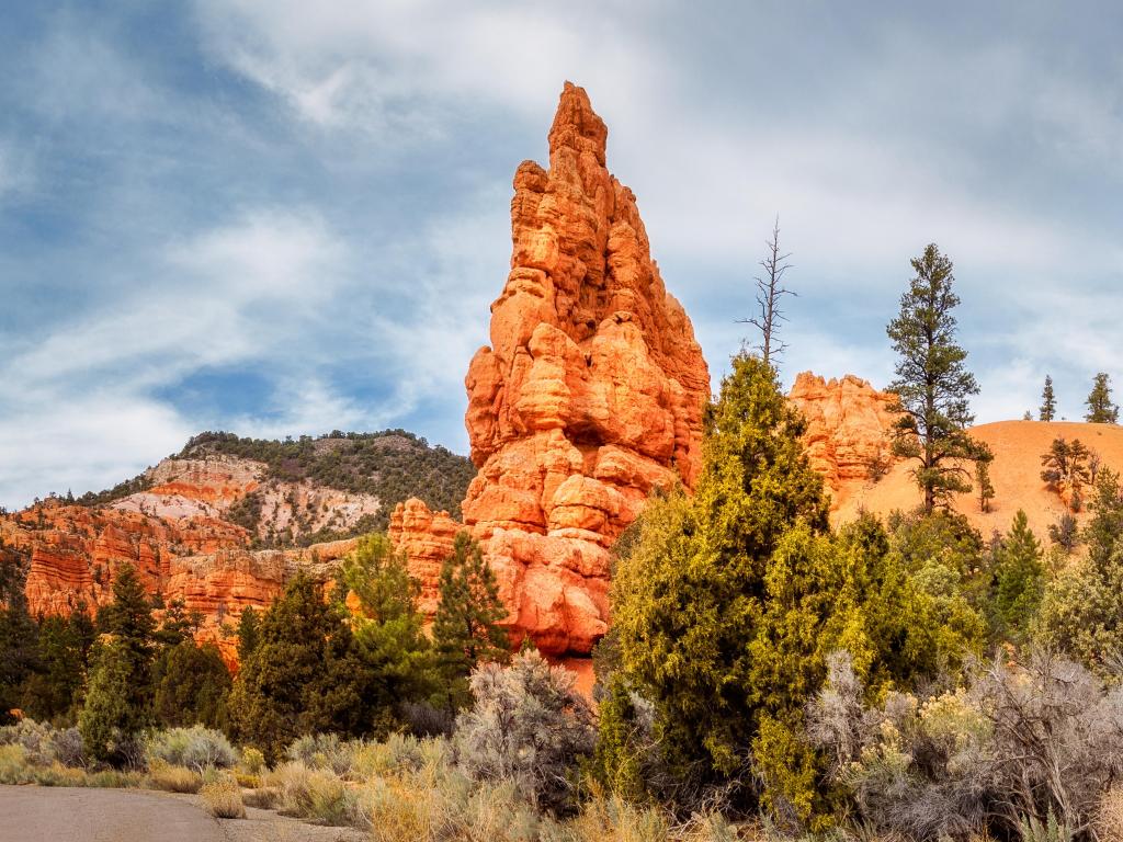 Bryce Canyon, Dixie National Forest, Utah, USA with a red canyon a shallow valley surrounded by much exposed, orange red limestone taken on a cloudy but sunny day.