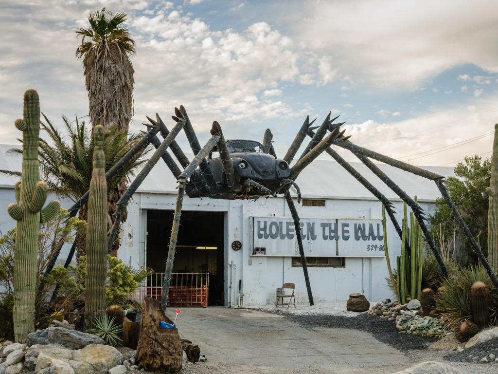 Roadside attraction in the Mojave Desert features a giant black spider welded together with a Volkswagon Bug car at the center.