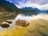 Golden Ears Provincial Park, BC, Canada with Alouette Lake in the foreground and the mountains in the distance reflecting in the calm water at sunrise. 