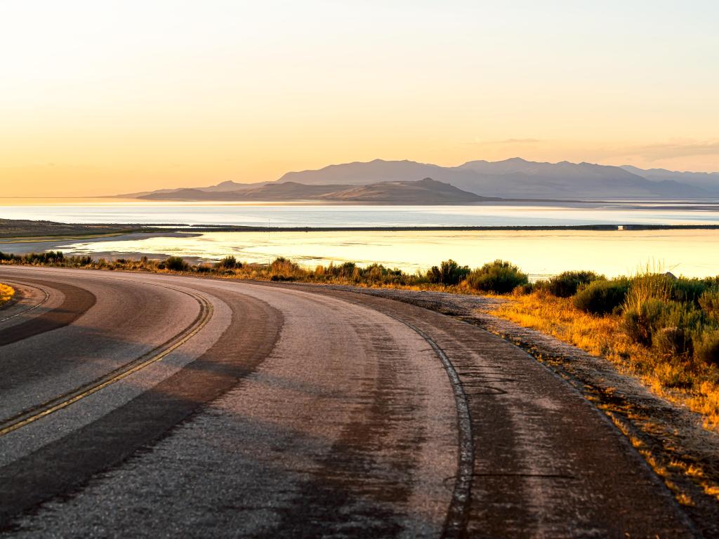 View of the Great Salt Lake at sunset from the road, running through Antelope Island State Park. Open road 