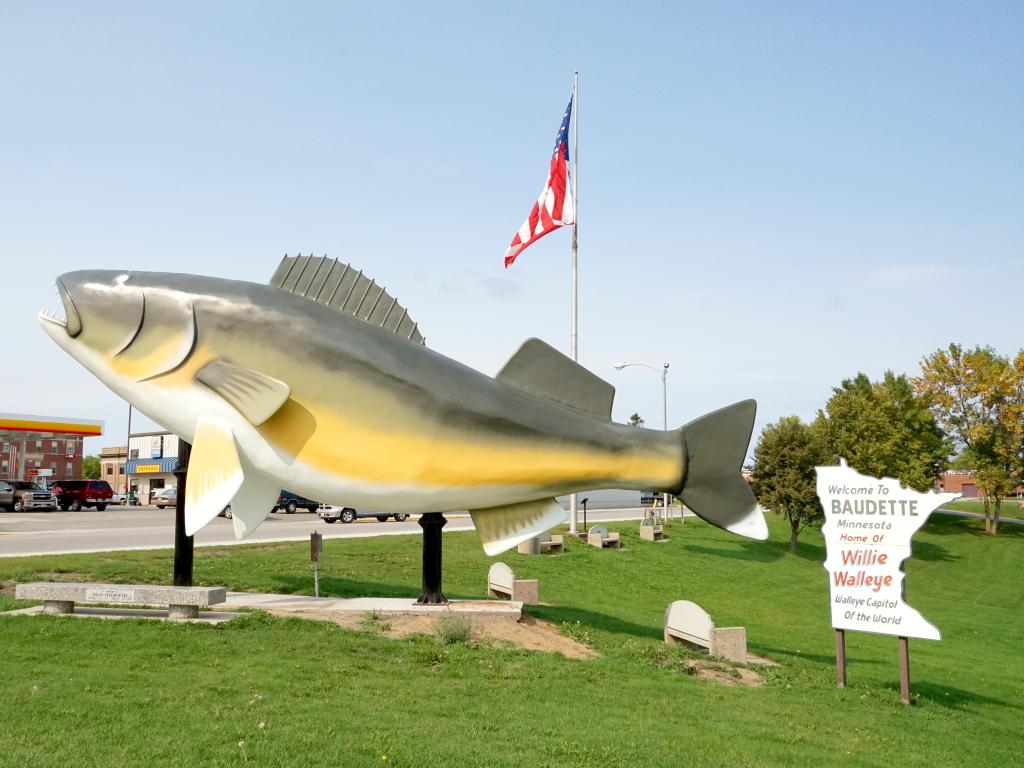 Fish sculpture with the American flag in the background on a sunny day