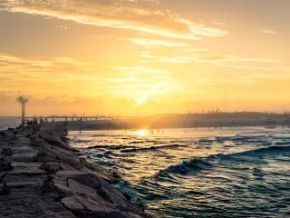 Sunset on the long pier of South Padre Island, with waves crashing in