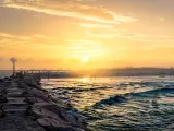 Sunset on the long pier of South Padre Island, with waves crashing in