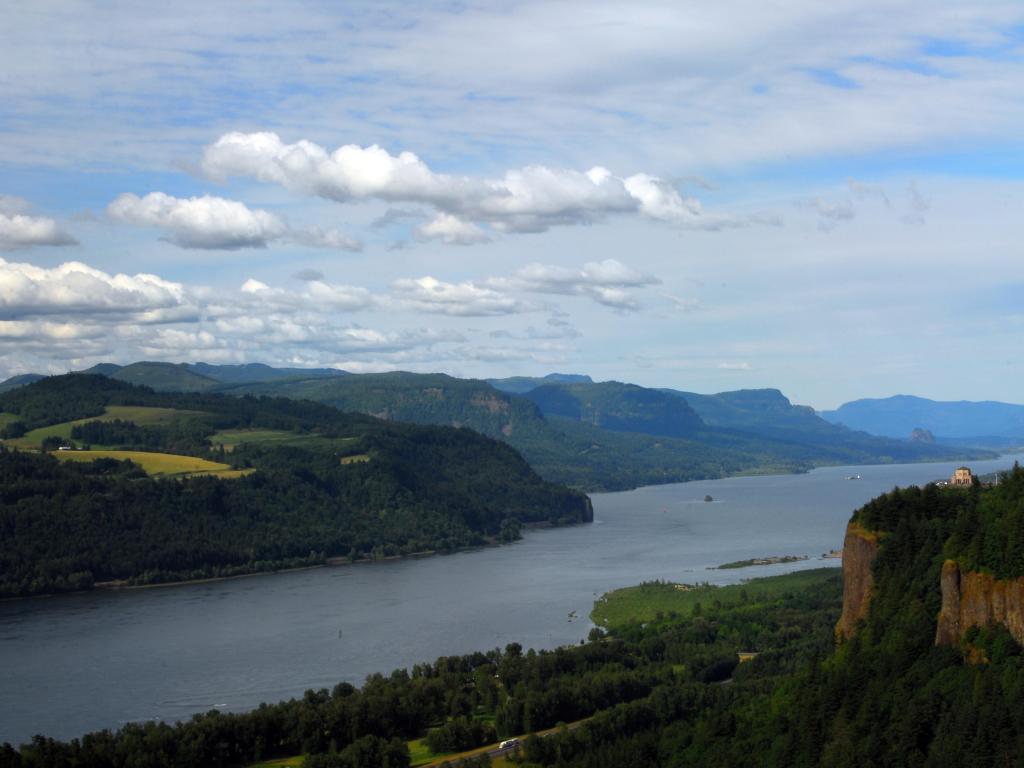 View of wide river with tree covered hill sides