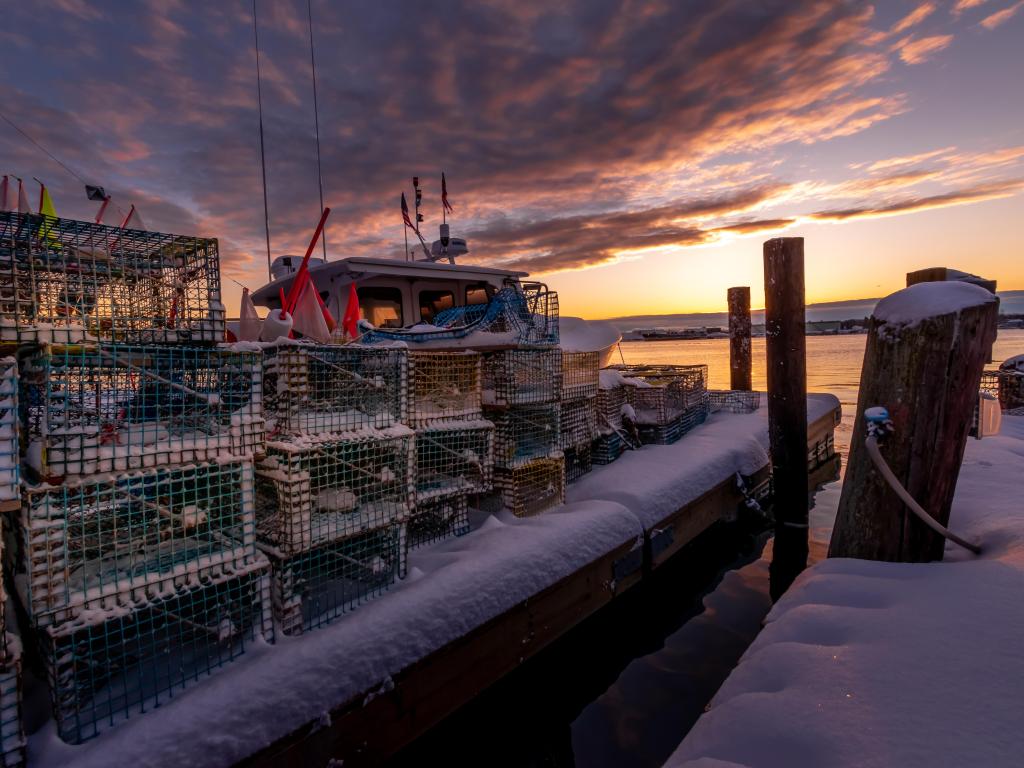 Dark winter sunrise on snowy and cold Portland Fish Pier with nets and crates
