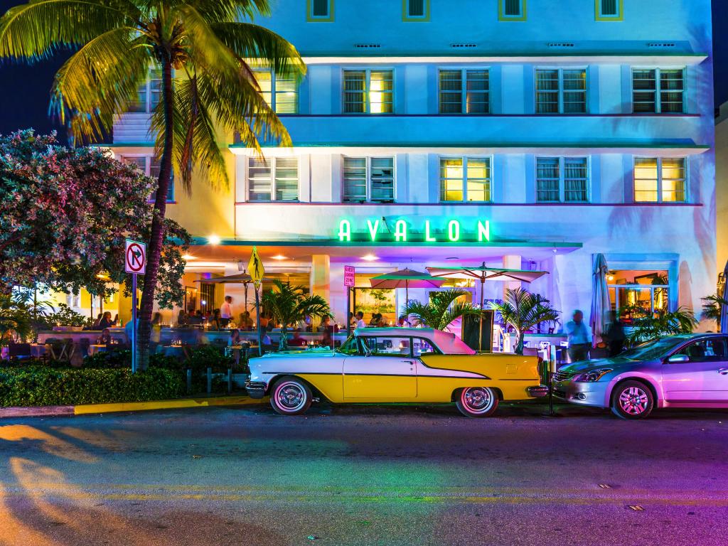 Avalon Hotel on Ocean Beach in Miami Beach at night with a vintage car parked outside