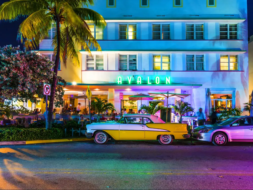Avalon Hotel on Ocean Beach in Miami Beach at night with a vintage car parked outside