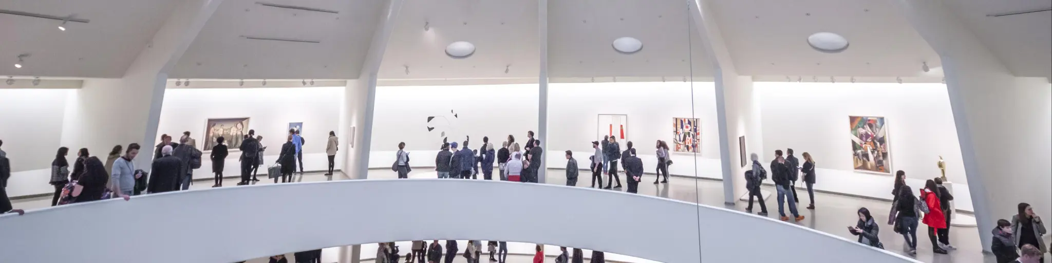 Busy interior of The Guggenheim Museum, with people walking between the gallery levels