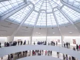 Busy interior of The Guggenheim Museum, with people walking between the gallery levels