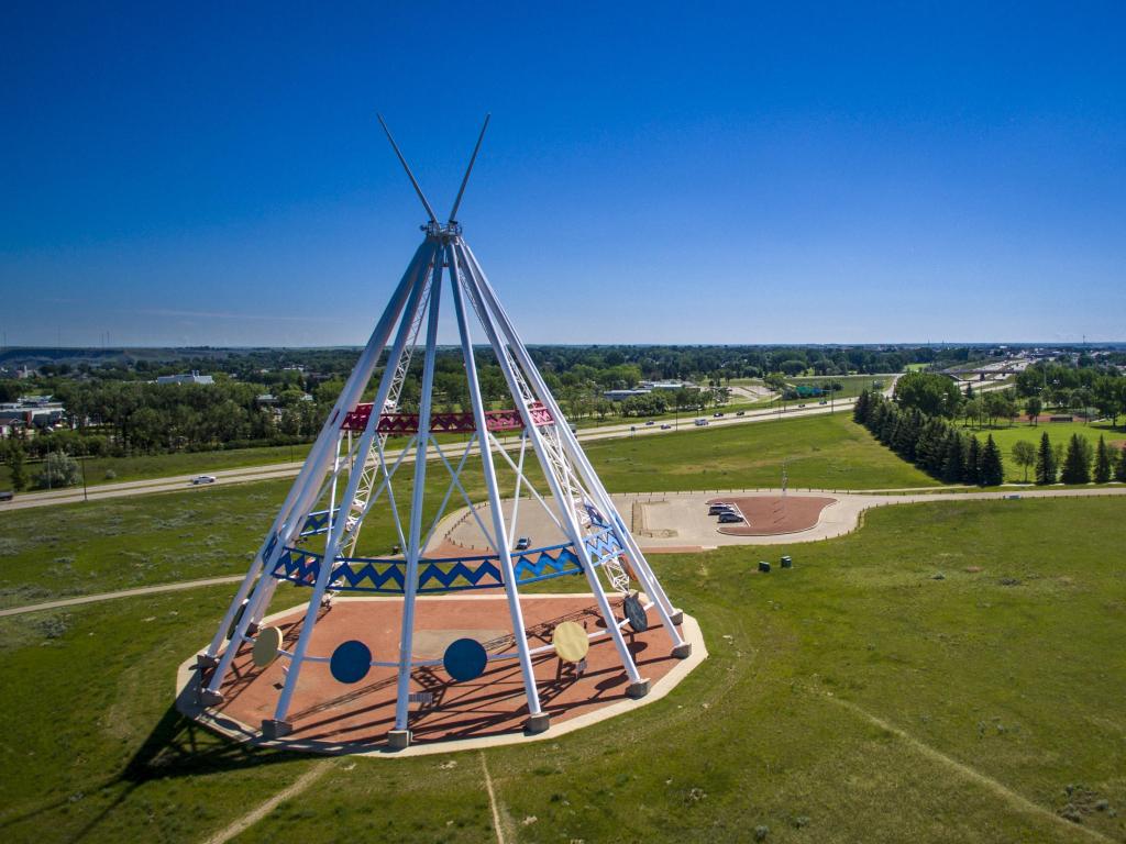 Saamis Teepee in the forefront with lush landscapes of Medicine Hat in the background on a bright sunny day