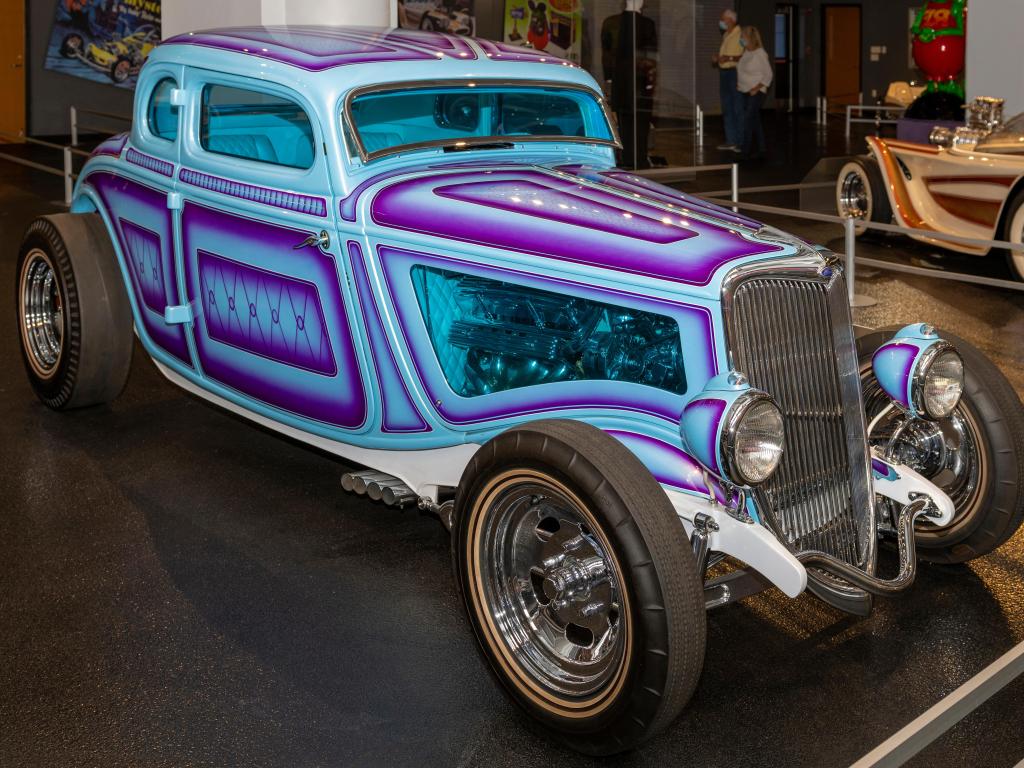 A flashy, vintage Corvette car in purple and teal in the museum
