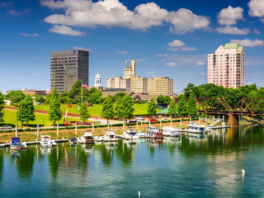 Augusta, Georgia, USA downtown skyline on the Savannah River on a sunny day with boats in the water in the foreground.