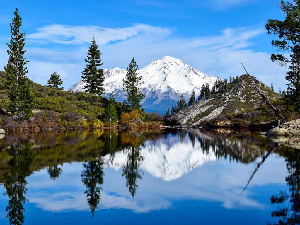 Mount Shasta, USA with Heart Lake in the foreground and the mountain covered in the distance in snow taken on a sunny day.