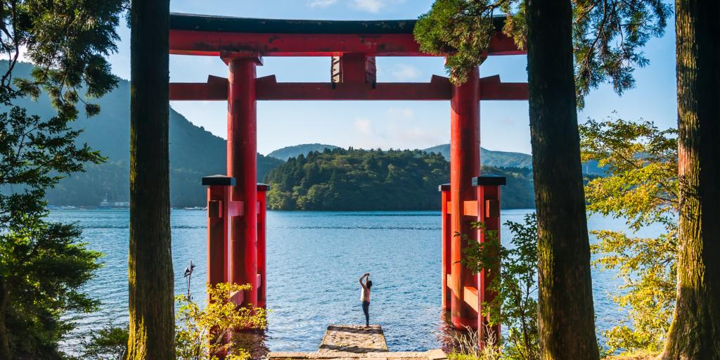 A person taking a photo of the Torii gate at Hakone Shrine, Japan 