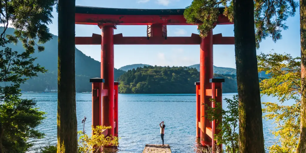 A person taking a photo of the Torii gate at Hakone Shrine, Japan 