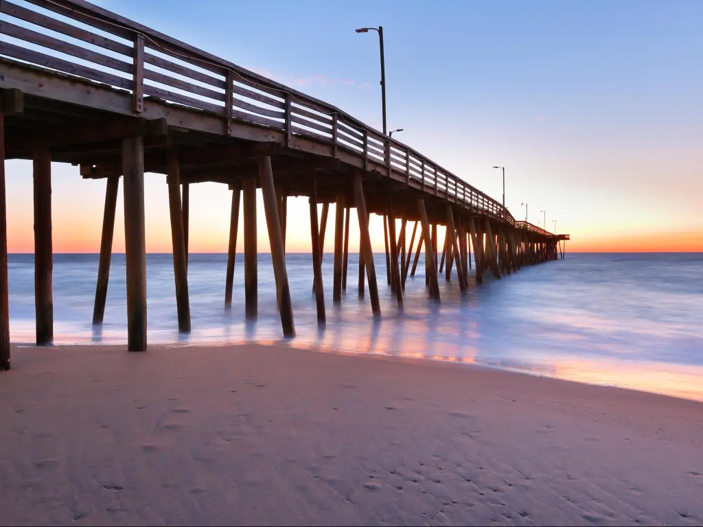Virginia Beach, Virginia, USA taken at the fishing pier at sunrise with soft sand and a calm sea.