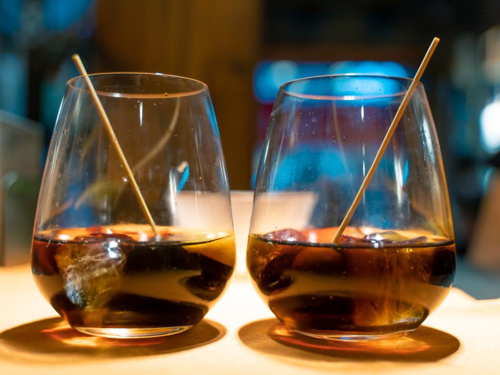 Two glasses with vermouth with a slice of orange and olives