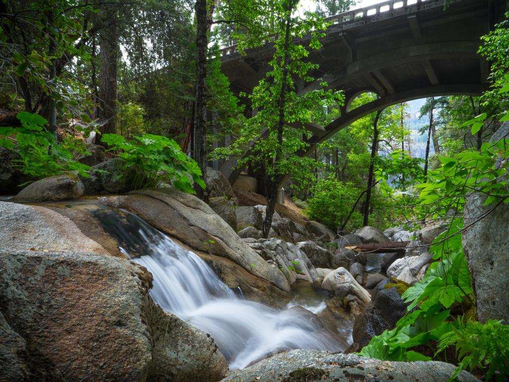 Smooth flowing water over forest boulders - Tamarack Creek arch bridge - Highway 120 in Yosemite National Park