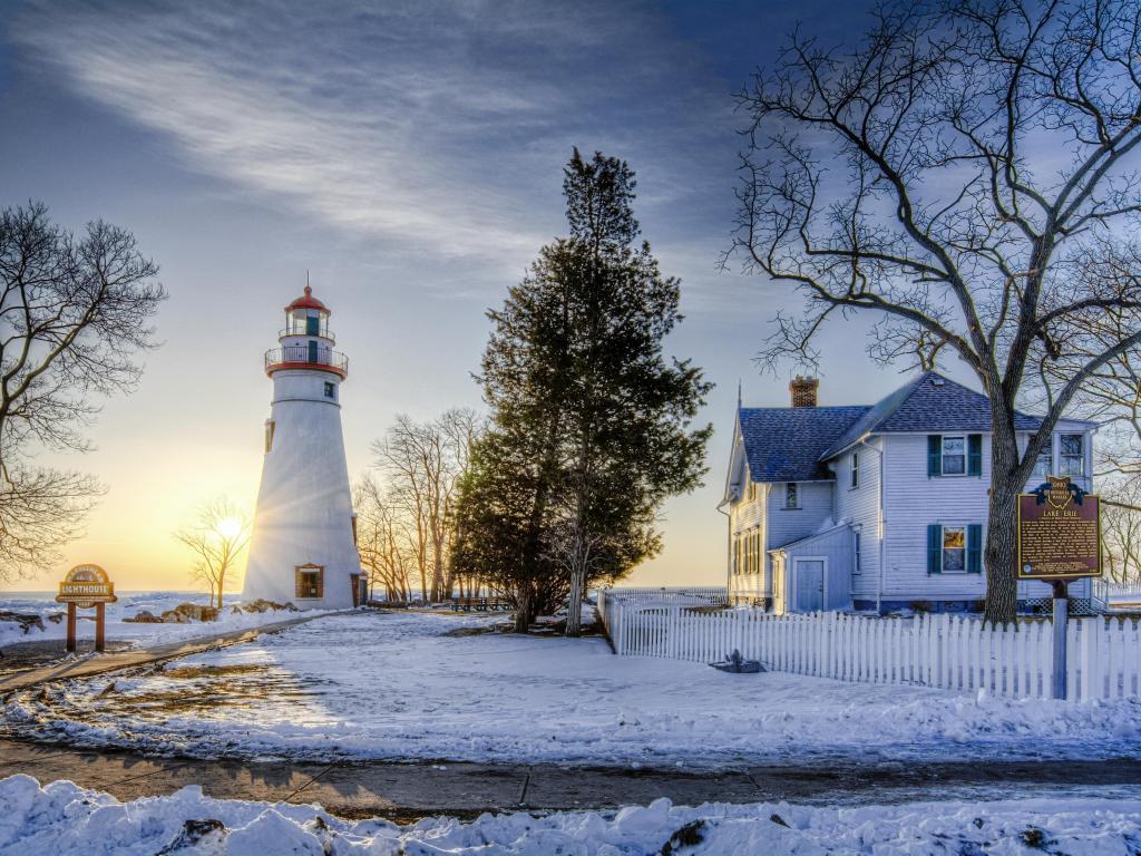 Marblehead Lighthouse seen here at sunrise in winter with snow and ice on the ground