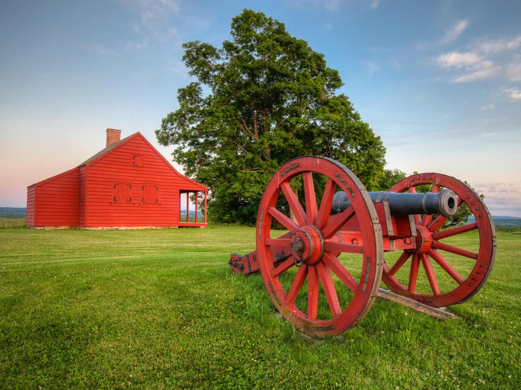 Cannon at Saratoga National Battlefield with Neilson Farm in the background.