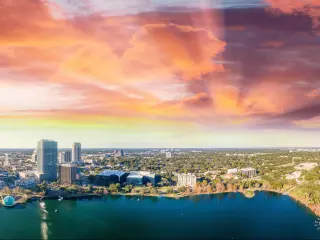 Aerial view of lake and high rise buildings with vivid sunset sky