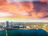 Aerial view of lake and high rise buildings with vivid sunset sky