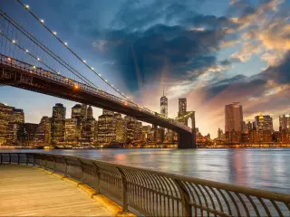 Manhattan, New York City, USA with a spectacular sunset city view, broad walk and bridge connecting into New York. 