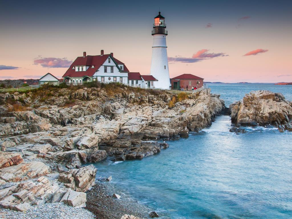 Cape Elizabeth Lighthouse, Portland, Maine, USA taken in early evening with rocks and the sea in the foreground.