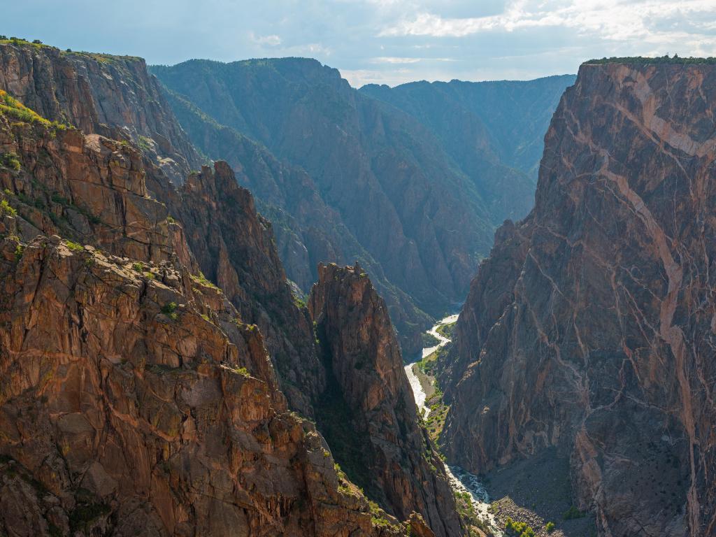 Black Canyon of the Gunnison National Park, Colorado with steep granite cliffs either side and a river cutting through the rock in the valley below.