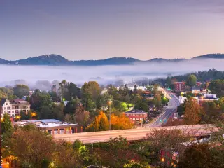 Asheville, North Carolina, downtown skyline at dusk with mountains and fog in the background