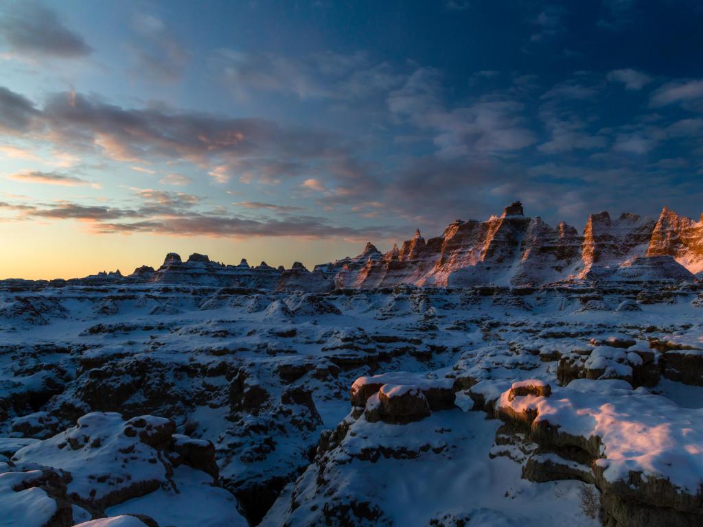 Sunrise over Badlands National Park in Winter, with snow dusting the jagged terrain