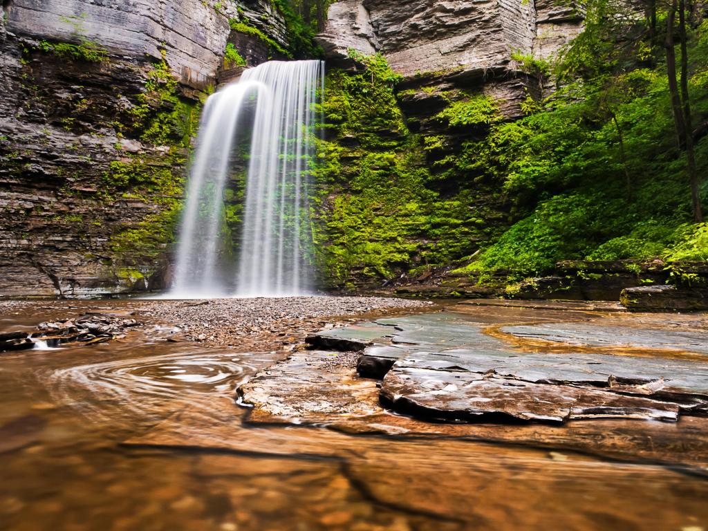 Eagle Cliff Falls, Finger Lakes, New York State, USA taken at Havana Glen Park with moss covered cliffs in the distance and a pool of water in the foreground.