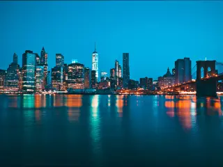 New York, USA with the famous panoramic view of the city at night, with the sea in the foreground and the skyscrapers in the distance. 