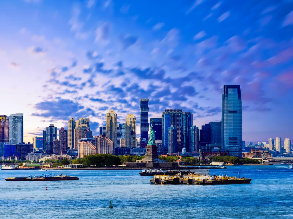 The skyline of Jersey City, New Jersey from New York Harbor with the Statue of Liberty in the foreground