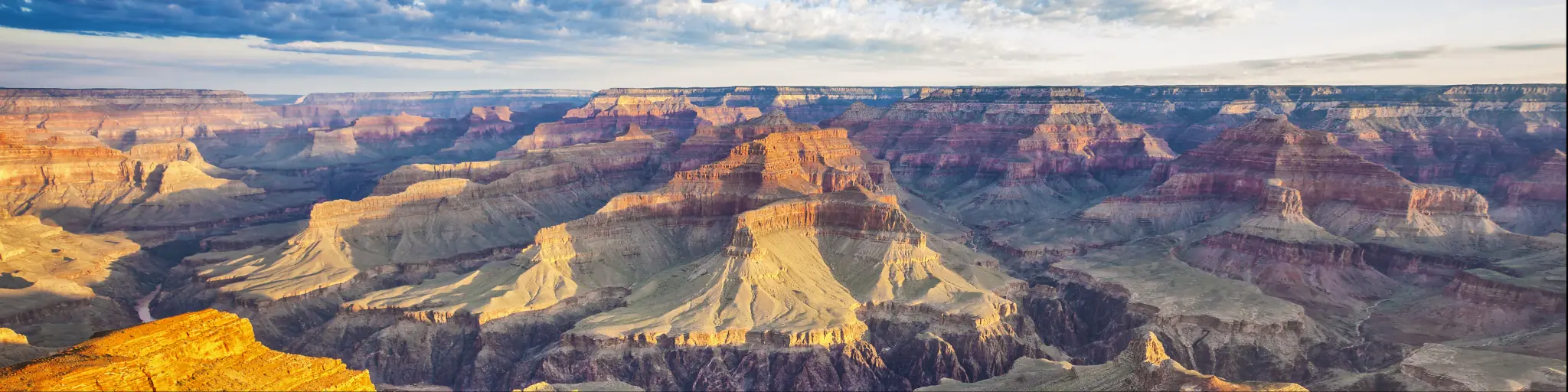 A breathtaking view of the Grand Canyon illuminated by the morning light with a cloudy sky