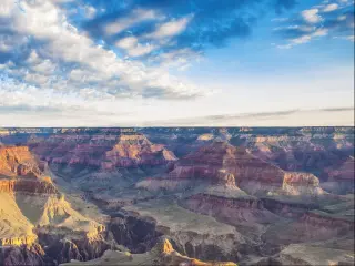A breathtaking view of the Grand Canyon illuminated by the morning light with a cloudy sky