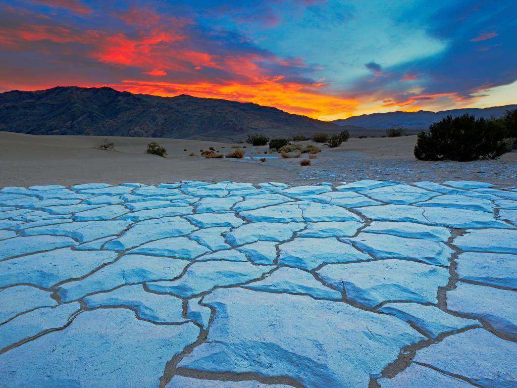Sunset at Death Valley with the white cracked Mesquite Flat Sand Dunes in the foreground 