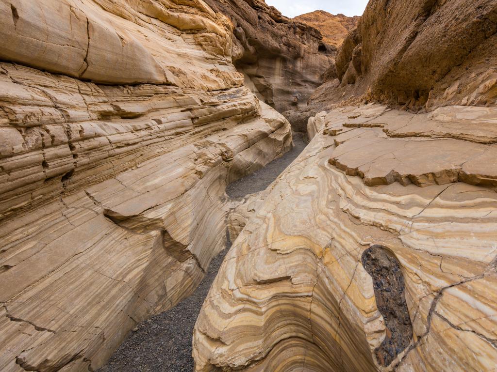 Mosaic Canyon, Death Valley National Park, California, USA with textured striations of marble walls enclosing the trail as it follows the canyon's curves. 