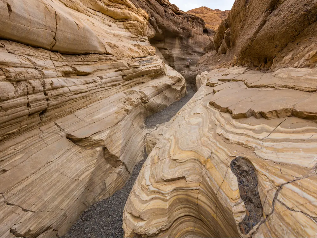 Mosaic Canyon, Death Valley National Park, California, USA with textured striations of marble walls enclosing the trail as it follows the canyon's curves. 