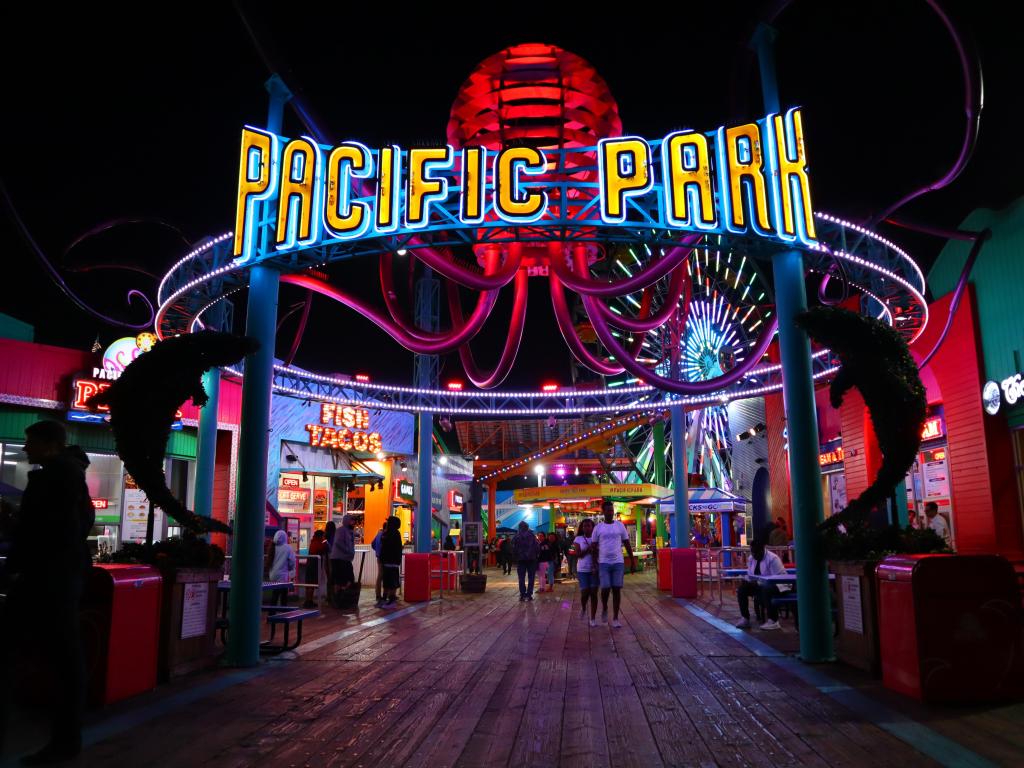 Night view of Santa Monica Pacific Park, with illuminated entrance and rides.