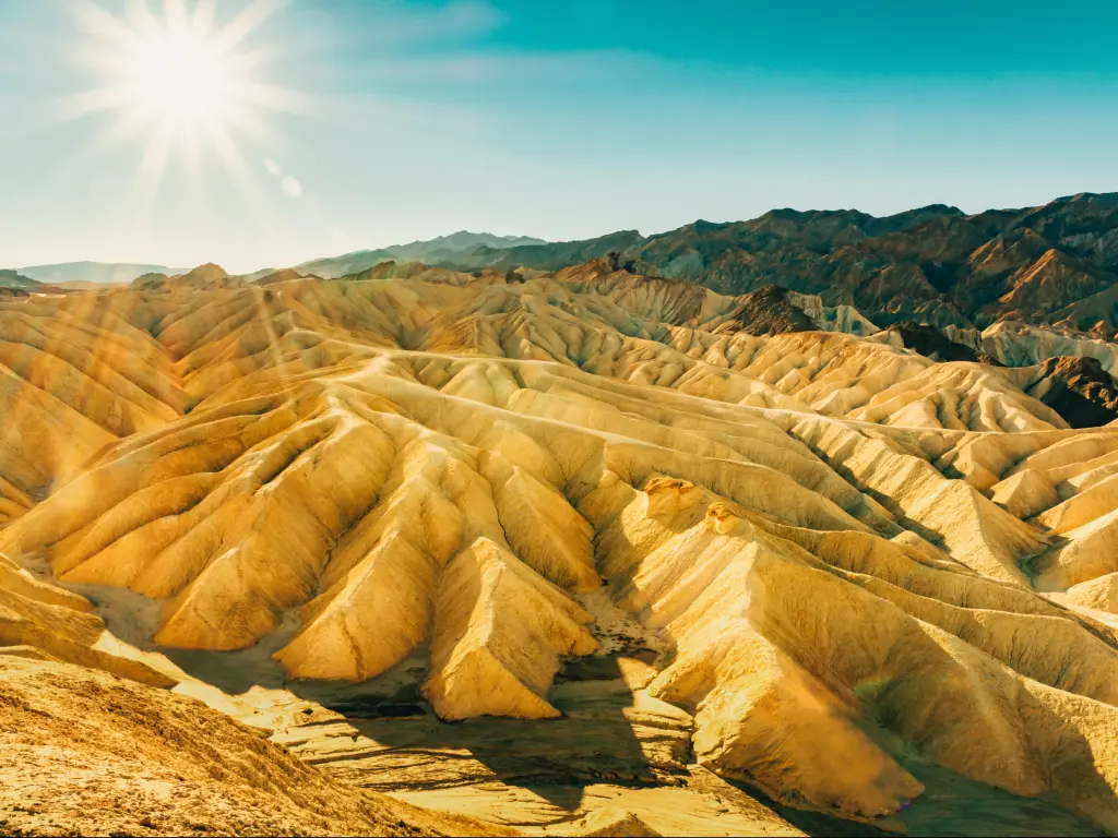 Death Valley's Zabriskie Point with unique rock and sand formations at sunrise.