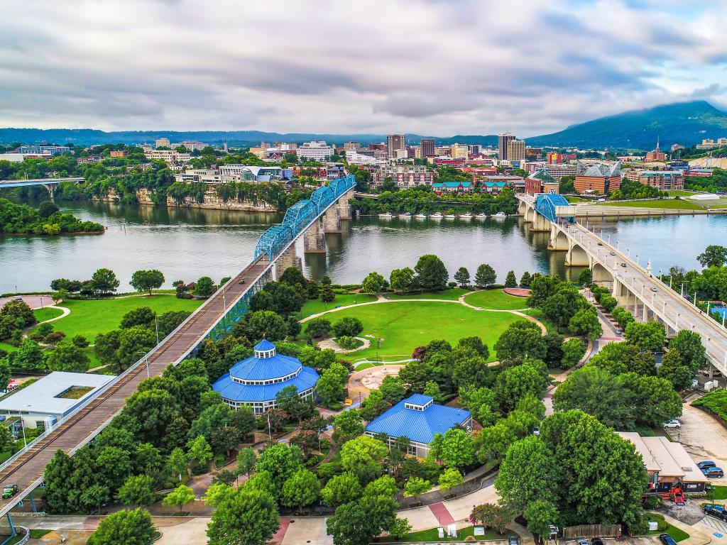 Chattanooga, TN, USA with a drone aerial view ofdDowntown Chattanooga with Coolidge Park and Market Street Bridge and mountains in the distance.