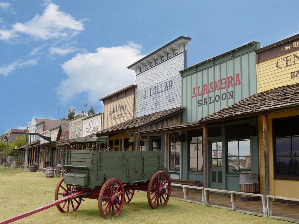 Old fashioned wagon in front of old fashioned wooden houses at a historical museum