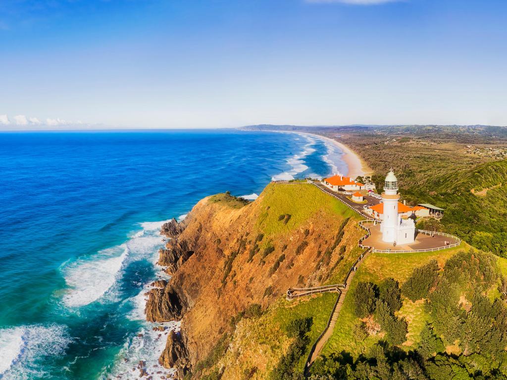 Byron Bay, Australia with the white stone Byron Bay lighthouse on the top of sandstone headland of Australian mainland the most eastern point in aerial panorama towards continent.